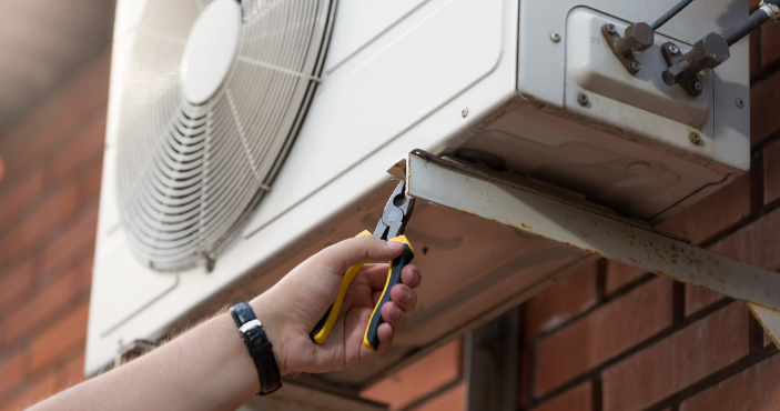 hand with pliers performing AC services