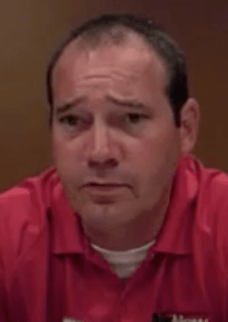 A man with short dark hair and a red collared shirt looks straight ahead with a neutral expression. He represents service professionals such as electricians and HVAC technicians, standing against a plain brown background.