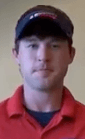 A man in a navy cap and red collared shirt, dressed like a typical service professional or electrician, stands facing the camera against a plain, light-colored background.