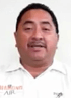 A man with short dark hair and a mustache, dressed in a white collared shirt, faces the camera against a plain background. Many electricians and HVAC technicians typically wear this attire.