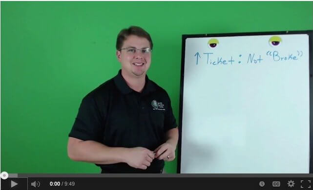 A man stands beside a whiteboard that reads "Ticket: Not 'Broke'," in front of a green screen, emphasizing the expertise of Service Professionals such as plumbers.