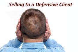 A man turns away, covering his ears with his hands. The text above says, "Selling to a Defensive Client." This image is ideal for plumbers and electricians who want to master tough customer conversations.