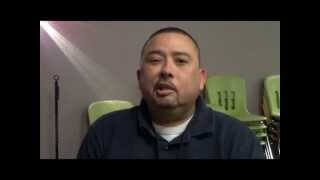 A man with short hair and a goatee—possibly a local plumber or HVAC technician—sits indoors in front of a stack of green chairs and faces the camera.