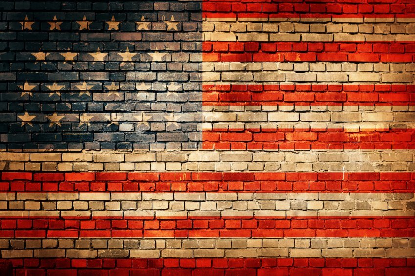 A brick wall displays a bold United States flag design, with red, white, and blue sections featuring stars and stripes. This mural honors Service Professionals like HVAC technicians and electricians who keep our nation running.