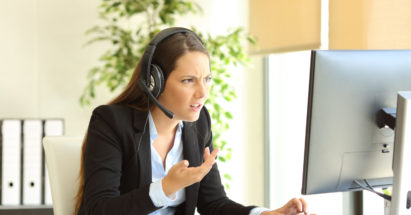 Angry tele marketer attending customer online at office