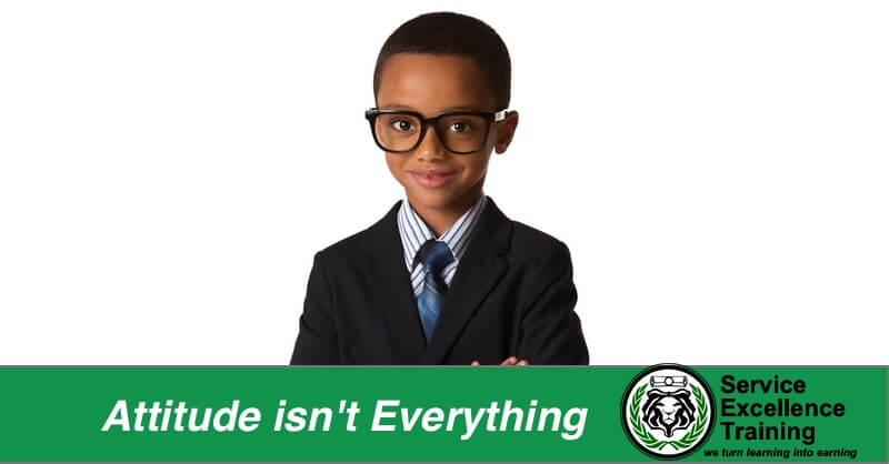 A young boy in glasses and a suit stands confidently against a white background. A green banner at the bottom declares, 