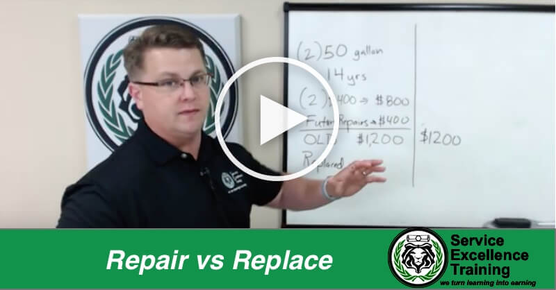 During a Service Excellence Training home services coaching session, a man in a black polo shirt explains repair vs. replacement costs on a whiteboard.