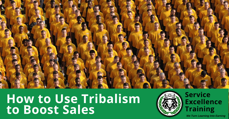 A large group of people in matching yellow shirts stands together. The text says, "How to Use Tribalism to Boost Sales," next to a Service Excellence Training logo. This image is ideal for home service business owners who want high-quality service training.
