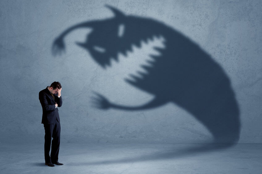 A man in a suit bows his head as the shadow of a large, menacing monster—symbolizing the challenges home service business owners face—looms on the wall behind him.