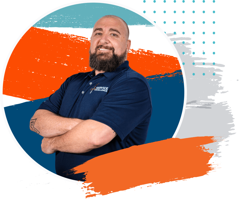 A bearded, tattooed man in a navy polo stands with his arms crossed against an abstract background—perfect inspiration for home service business owners ready to press play and boost their sales.